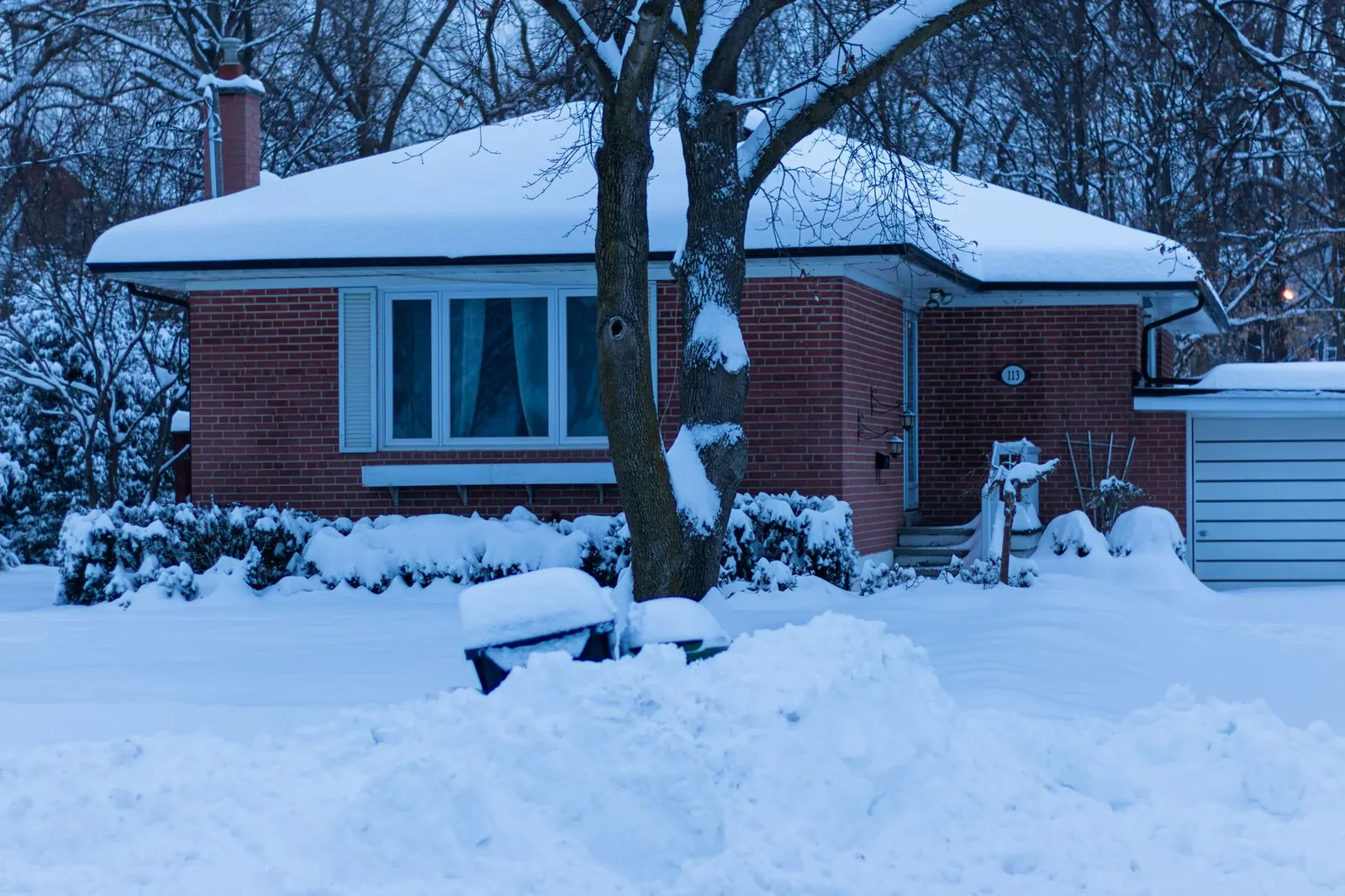 A serene winter morning scene of a snow-covered house in Toronto, Canada.