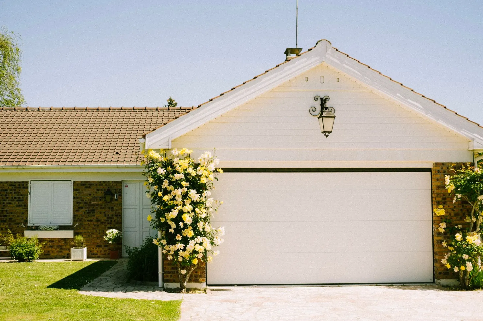 A lovely suburban home with a prominent garage and flowering plants, epitomizing suburban charm and tranquility.